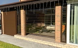 Прозрачные рольставни для террасы кирпичного дома